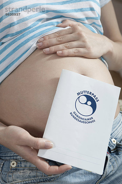 Pregnant woman holding maternity log protocol book