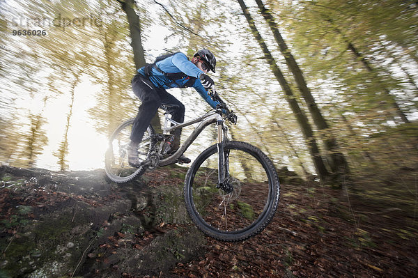 Mountain biker riding downhill in a forest