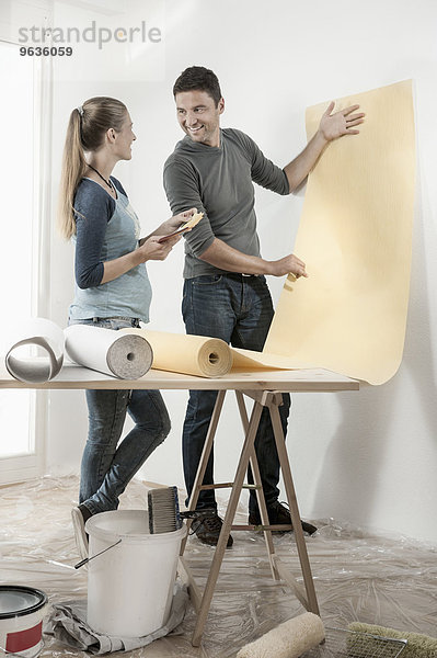 Couple choosing wallpaper for their new home