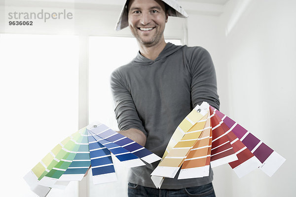 Man showing colour samples and smiling