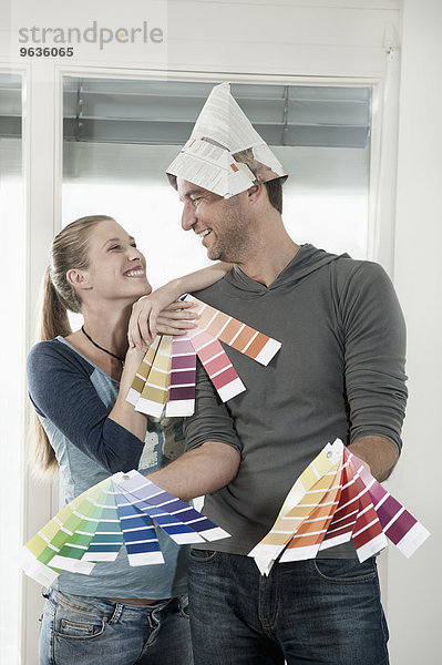 Couple choosing colour samples and smiling