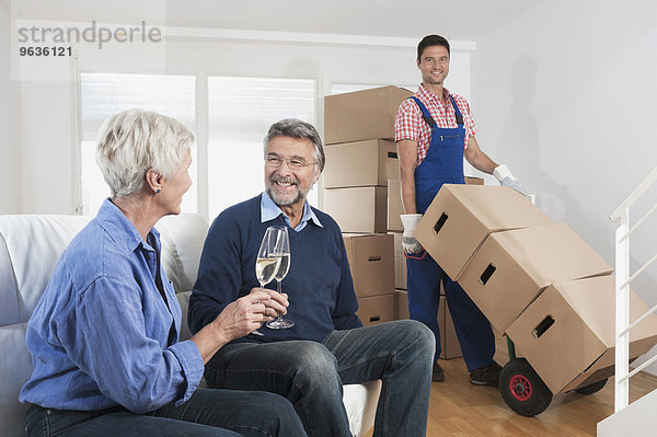 Senior couple celebrating moving to new house with champagne