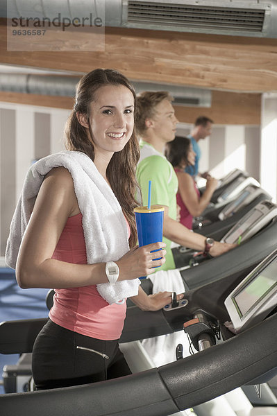 Portrait young woman treadmill fitness-studio