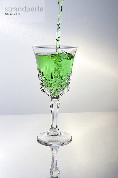 Grüne Flüssigkeit wird in ein Glas geschüttet