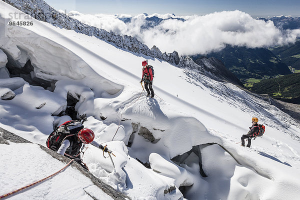 Bergsteiger beim Aufstieg auf den Löffler über den Trippachkees  Schneescheide  Seilschaft  hier bei der Randspalte der Trippachscharte  unten das Ahrntal  Tauferer Ahrntal  Pustertal  Südtirol  Italien  Europa