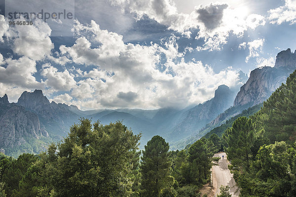 Straße durch ein Tal mit Felsenklippen zwischen Wolken  Col de Bavella  Bavella-Massiv  Korsika  Frankreich  Europa