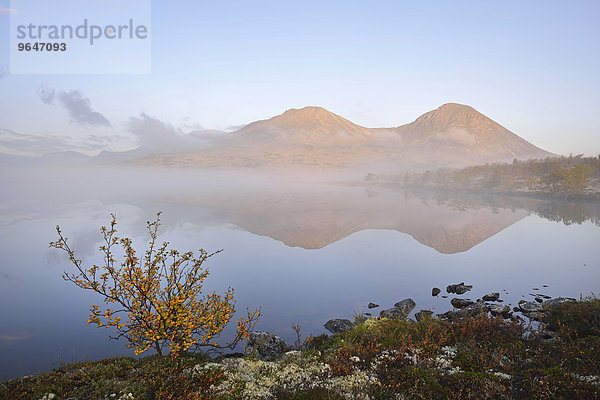 Gipfel der Berggruppe Stygghøin oder Stygghoin  spiegeln sich im See Dørålstjørnin oder Doralstjornin  Rondane-Nationalpark  Norwegen  Europa