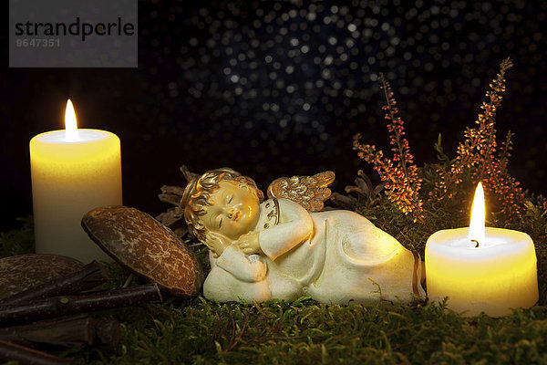 Weihnachtsdekoration  Engel schläft bei Kerzenschein