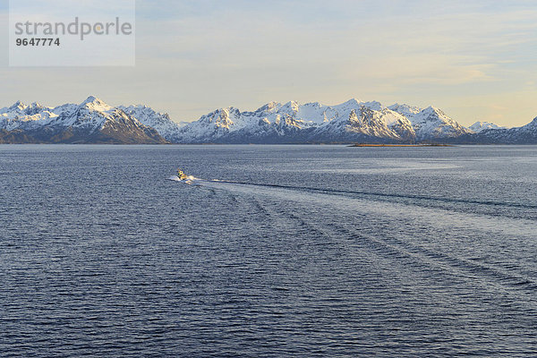 Boot fährt in den Sortlandsund  hinten schneebedeckte Berggipfel  Sortlandsund  Nordland  Vesterålen  Norwegen  Europa