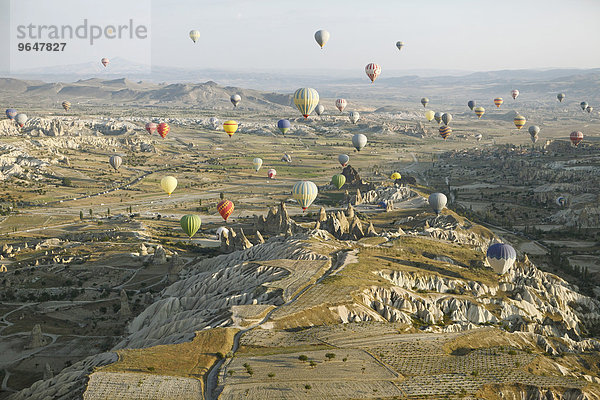 Heißluftballons über Höhlenwohnungen und Tuffsteinformationen im Morgenlicht  Provinz Nevsehir  Kappadokien  Anatolien  Türkei  Asien