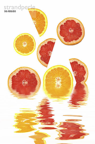 Orangenscheiben und Grapefruitscheiben mit Spiegelung im Wasser
