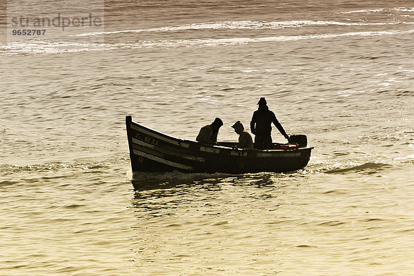 Silhouette  drei Fischer in einem kleinen Boot  Einfahrt in den Hafen  Essaouira  Region Marrakesch-Tensift-El Haouz  Marokko  Afrika
