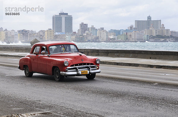 Amerikanischer Oldtimer auf dem Malecón  dahinter das moderne Stadtviertel Vedado  Centro Habana  Havanna  Ciudad de La Habana  Kuba  Nordamerika