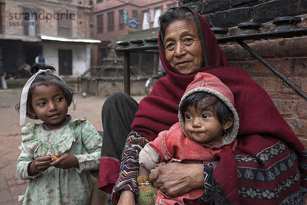 Ältere Nepalesin mit zwei Kindern  Bhaktapur  Nepal  Asien