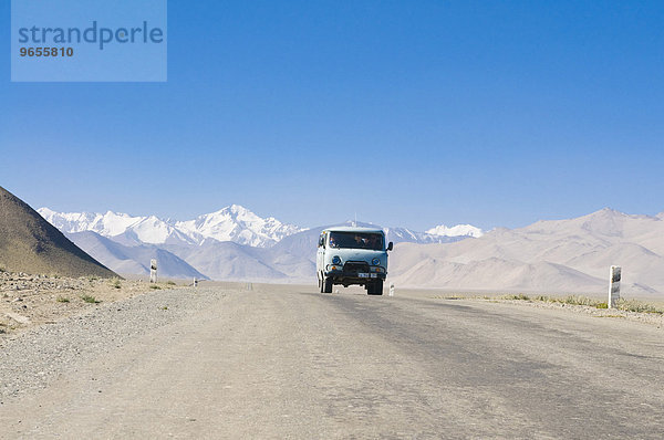 Landstraße führt zu schneebedecktem Gebirge  Karakul  Pamirgebirge  Tadschikistan  Zentralasien  Asien