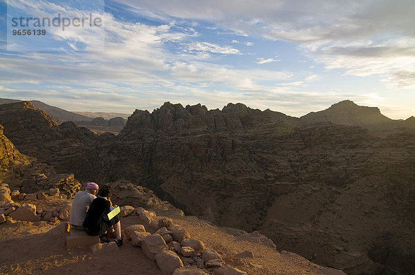 Paar mit Blick über die Felsen nahe Petra in der Dämmerung  Jordanien  Vorderasien  Asien