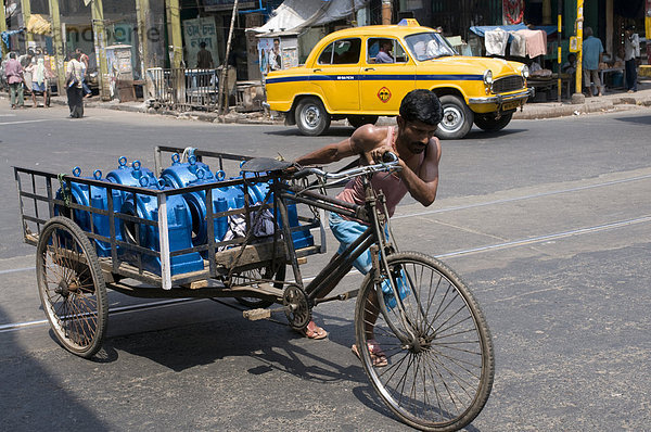 Mann schiebt seine Rikscha durch den Verkehr  Kalkutta  Indien  Asien
