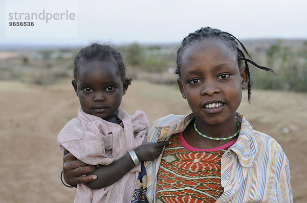 Junges muslimisches Mädchen trägt ein kleines Kind  Yabello  Südäthiopien  Äthiopien  Afrika