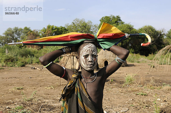 Junges Mädchen vom Stamm der Mursi mit Regenschirm auf dem Kopf  Magon Nationalpark  südliches Omotal  Südäthiopien  Äthiopien  Afrika