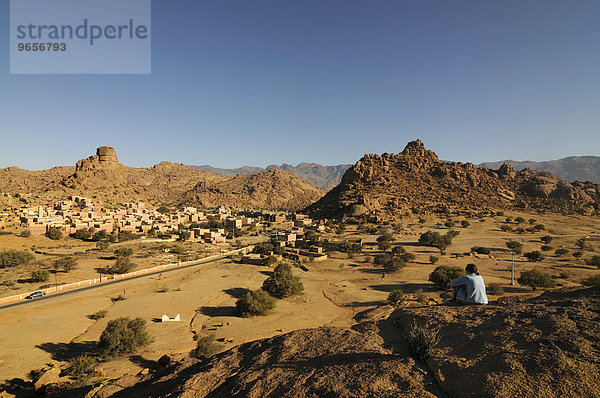 Touristin entspannt sich vor einem malerischen Bergdorf bei Tafraoute  Südmarokko  Marokko  Afrika