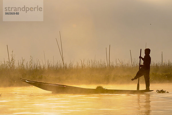 Fischer im Morgenlicht in traditionellem Kanu  Inle-See  Bagan  Myanmar  Burma oder Birma  Südostasien  Asien