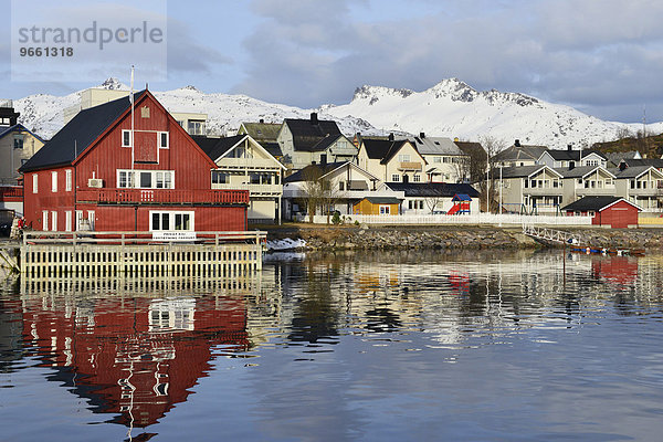 Rotes Haus mit Privatkai und mehrere Häuser des Ortes  vor weißen Bergen  Svolvær  Lofoten  Nordland  Norwegen  Europa