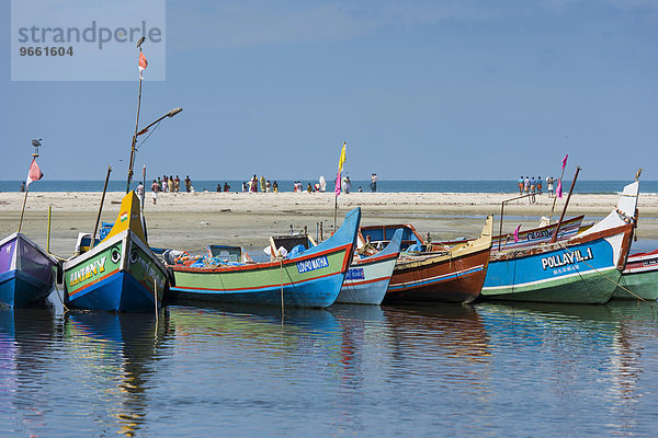 Bunt bemalte Fischerboote und Menschen am Strand  bei Alappuzha  Kerala  Indien  Asien