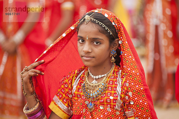 Portrait einer jungen Frau in der typischen farbenfrohen Tracht der Rajasthanis beim Kamelmarkt und Viehmarkt Pushkar Mela  Pushkar  Rajasthan  Indien  Asien