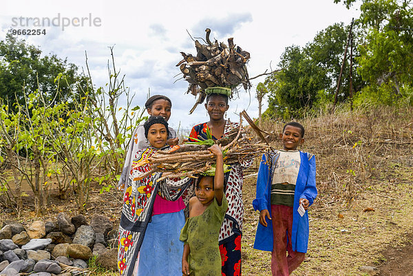 Lächelnde Mädchen tragen Brennholz  Moheli  Komoren  Afrika
