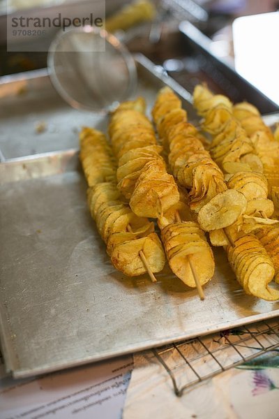 Frittierte Kartoffelchips auf Holzspiessen (Thailand)