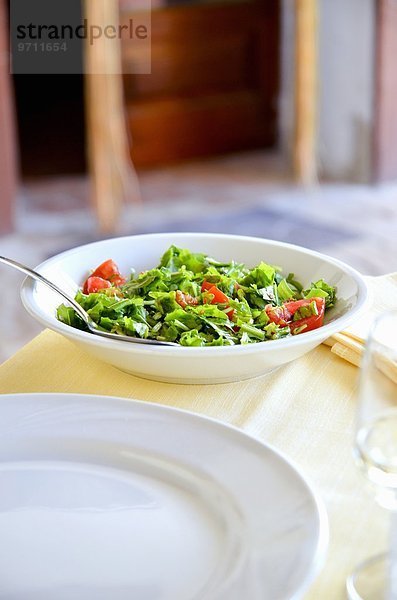 Gehackter Rucola-Tomaten-Salat auf einem Restauranttisch (Italien)