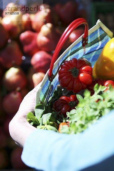 Frische Tomaten und Kräuter in karierter Einkaufstasche