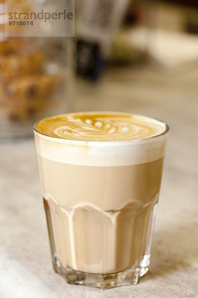 Caffè latte mit Milchschaum im Glas