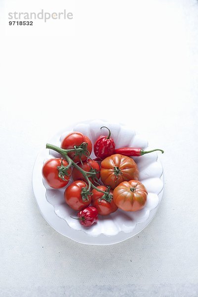 Frische Chilischoten und Tomaten auf Teller