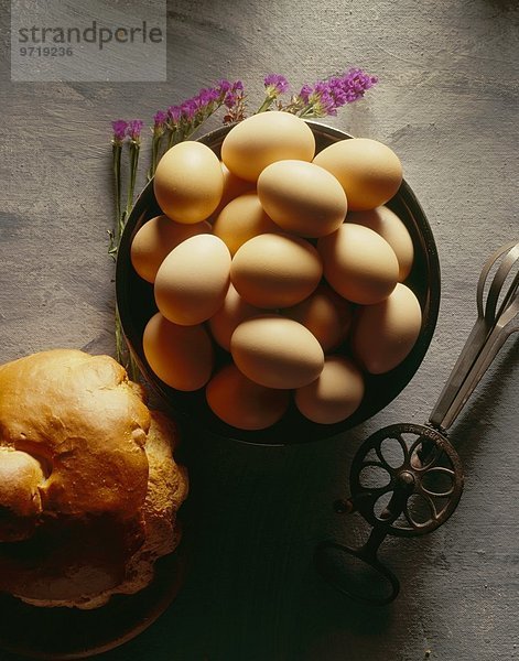 Braune Eier in Schüssel  alter Rührbesen und Brot