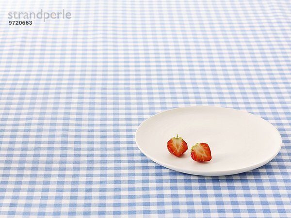 Zwei halbe Erdbeeren auf Teller