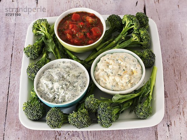 Verschiedene Dips (Salsa  Raita und Käse-Schnittlauch-Dip) mit Brokkoli