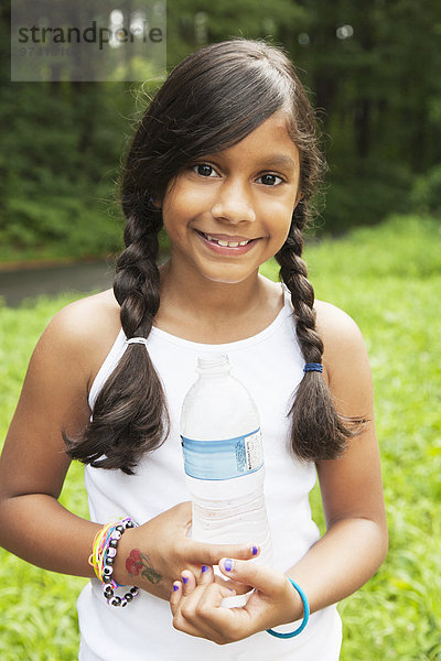 Wasser lächeln Hispanier halten Flasche Mädchen