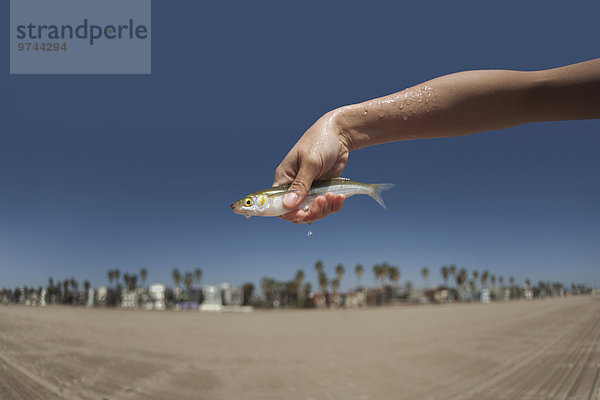 Woman holding live  dripping fish