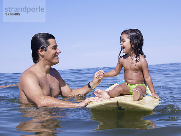Menschlicher Vater Hispanier halten Surfboard Tochter