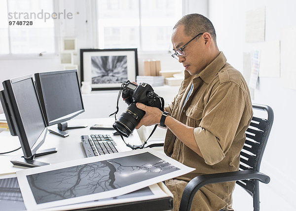 benutzen Schreibtisch Blick in die Kamera Fotoapparat Kamera Fotograf südkoreanisch