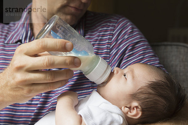 Menschlicher Vater Close-up Baby Flasche füttern