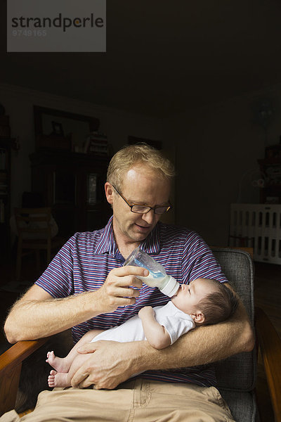 Menschlicher Vater Sessel Baby Flasche füttern