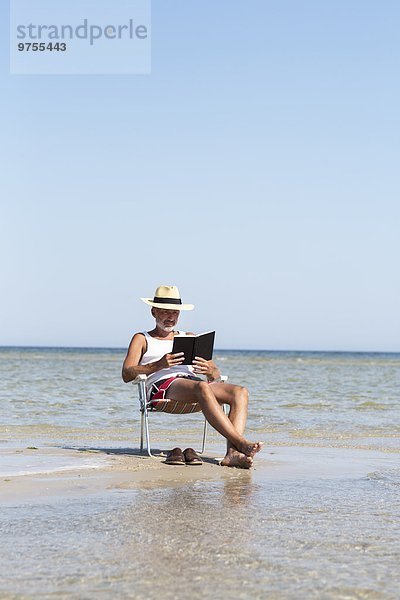 Mann Buch Strand reifer Erwachsene reife Erwachsene Taschenbuch vorlesen