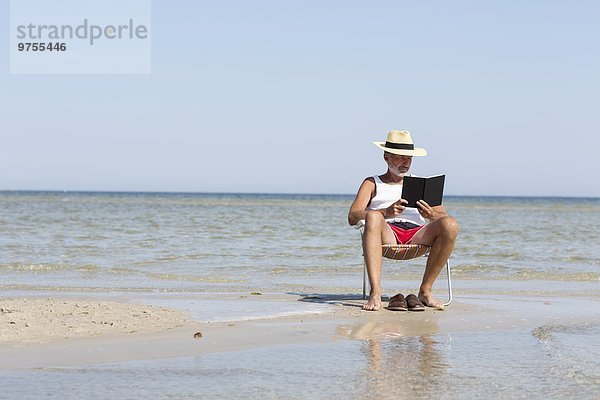 Mann Buch Strand reifer Erwachsene reife Erwachsene Taschenbuch vorlesen