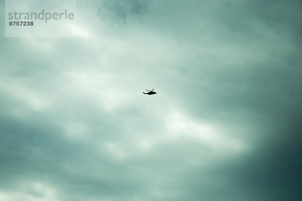 Norwegen  Hubschrauber bei bewölktem Himmel