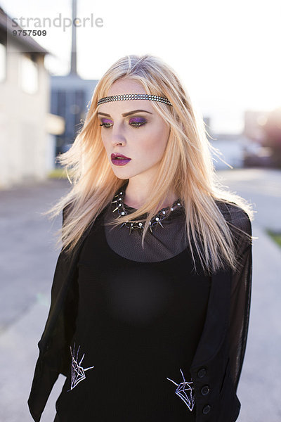 Porträt einer rouged blonden Frau mit Haarband in schwarzer Kleidung