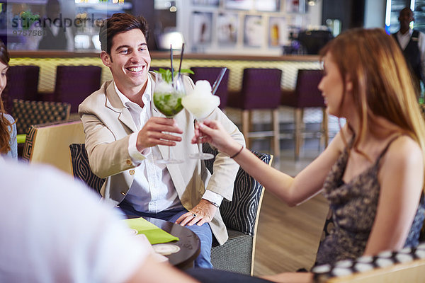 Mann und Frau klirrende Cocktailgläser an der Hotelbar