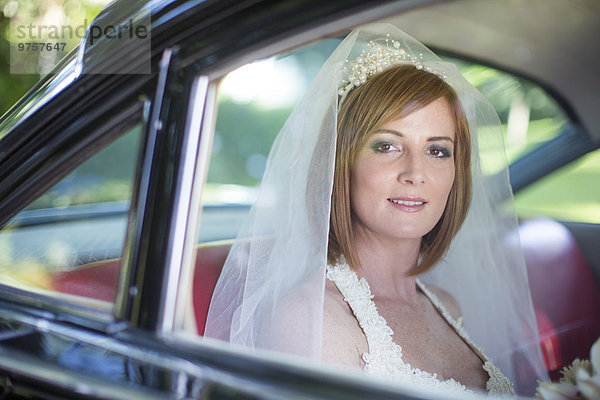 Braut sitzt im Auto vor der Hochzeit