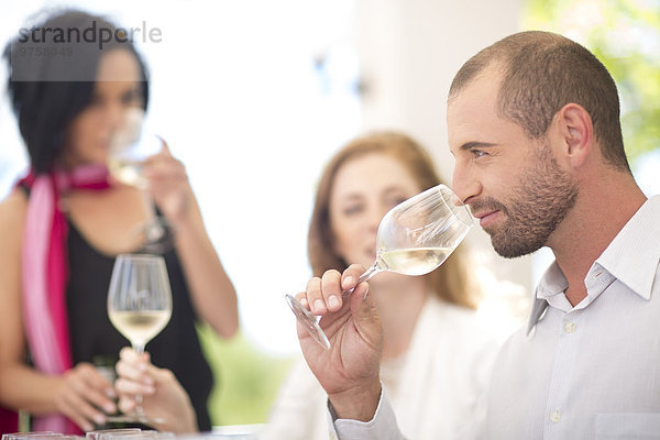 Weißwein riechender Mann bei einer Weinprobe